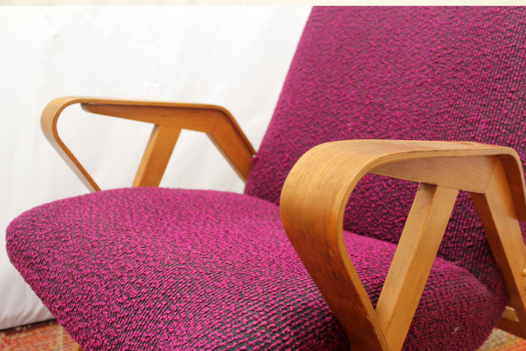 a purple chair with a wooden arm rest.
