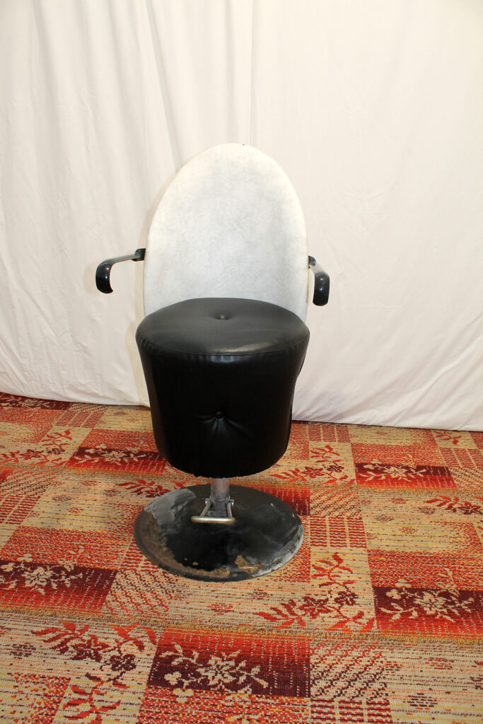 a black and white chair sitting on top of a rug.