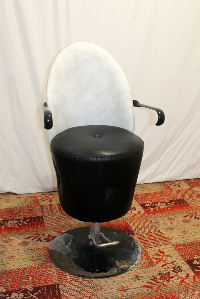 a black chair with a white cushion on top of it.