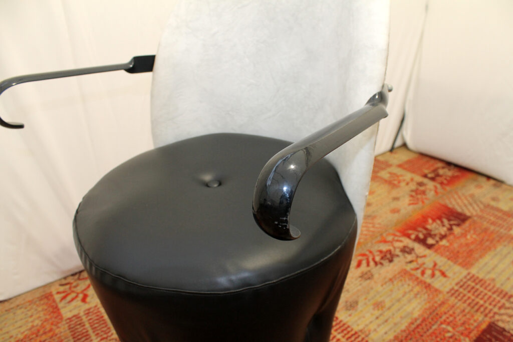 a black stool with a metal handle on it.