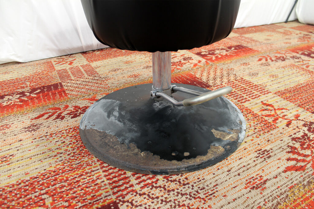 ein schwarzer Stuhl auf einem Teppich.